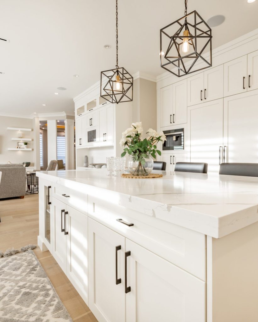 Warm,White,Kitchen,With,Expansive,Countertops,Island,High,End,Appliances